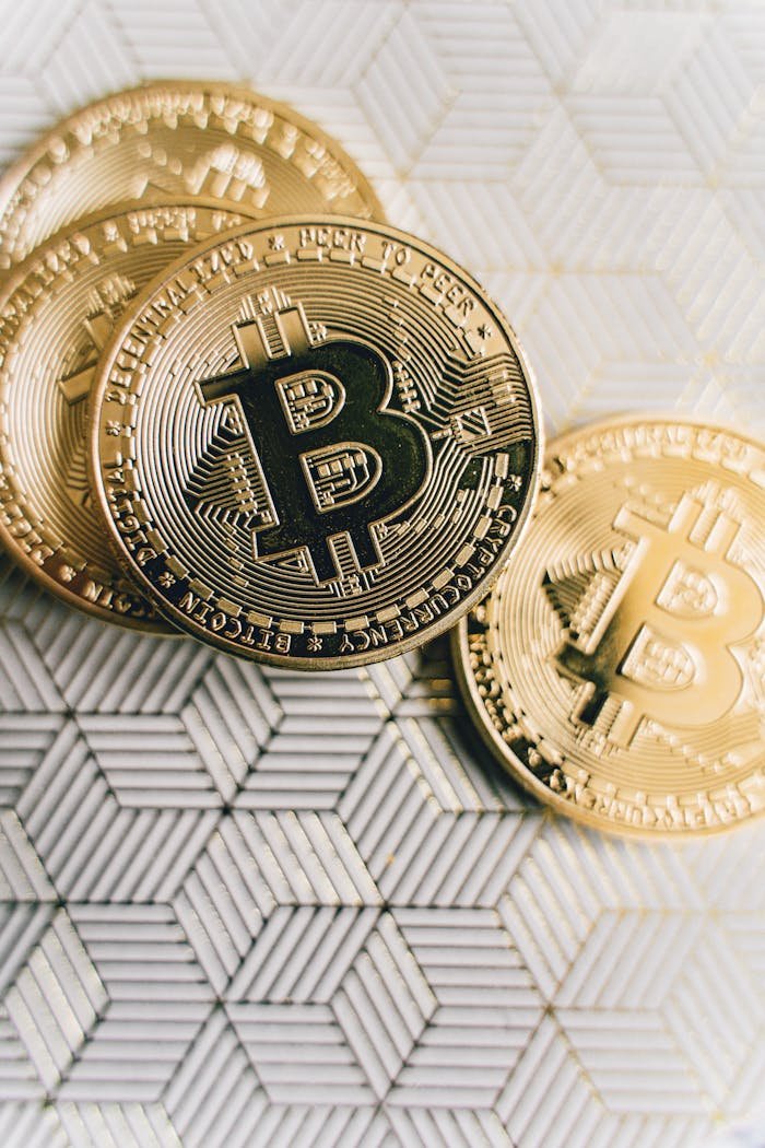 Close-up of Bitcoin coins placed on a geometric patterned surface, representing cryptocurrency and finance.